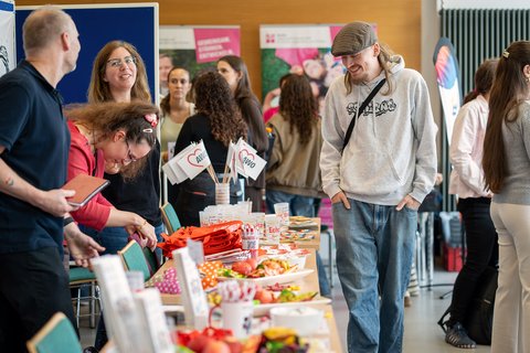 Blick auf die Tische der Träger mit Goodies und Infomaterial (öffnet Vergrößerung des Bildes)