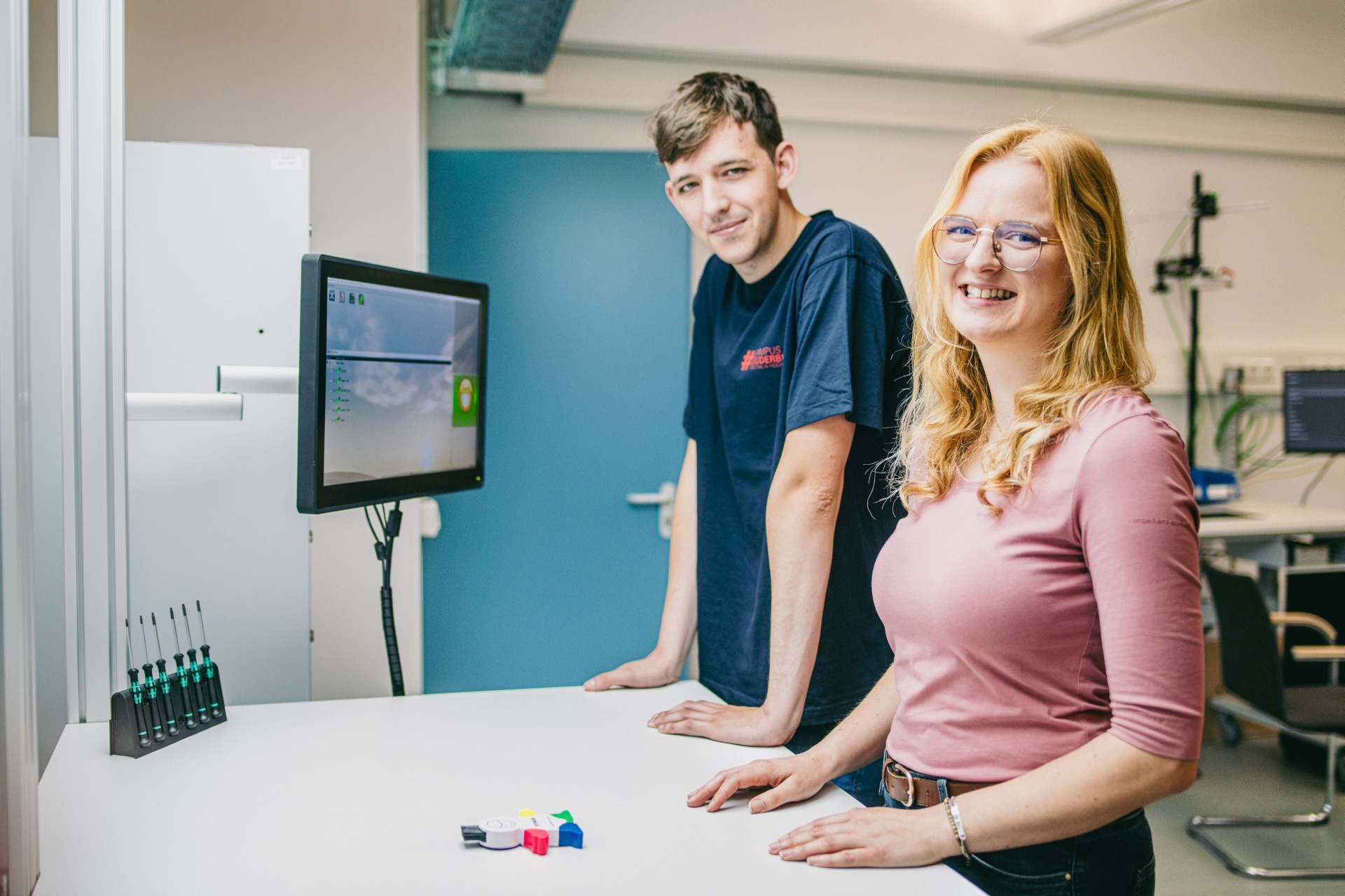 Zwei Studierende, die mit Hilfe des Schlauen Klaus (digitales Assistenzsystem) ein Produkt korrekt zusammengefügt haben.