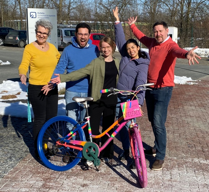 Das Team Radverkehrsmanagement der Ostfalia-Hochschule hinter dem bunt angemalten Vielfalts-Fahrrad mit der Aufschrift „Für Demokratie und Vielfalt“