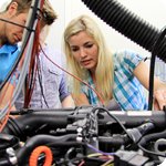 Ein Student und eine Studentin schauen in Motorrad eines Fahrzeugs